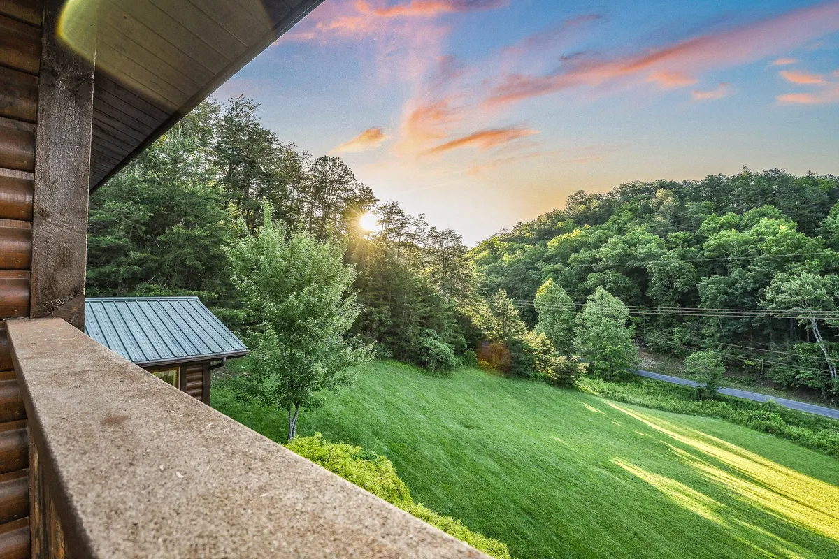A serene exterior scene featuring sunset-lit mountains, lush greenery, and a tranquil atmosphere. The view invites you to imagine nature walks, peaceful reflection, and the scenic beauty that defines the local area.